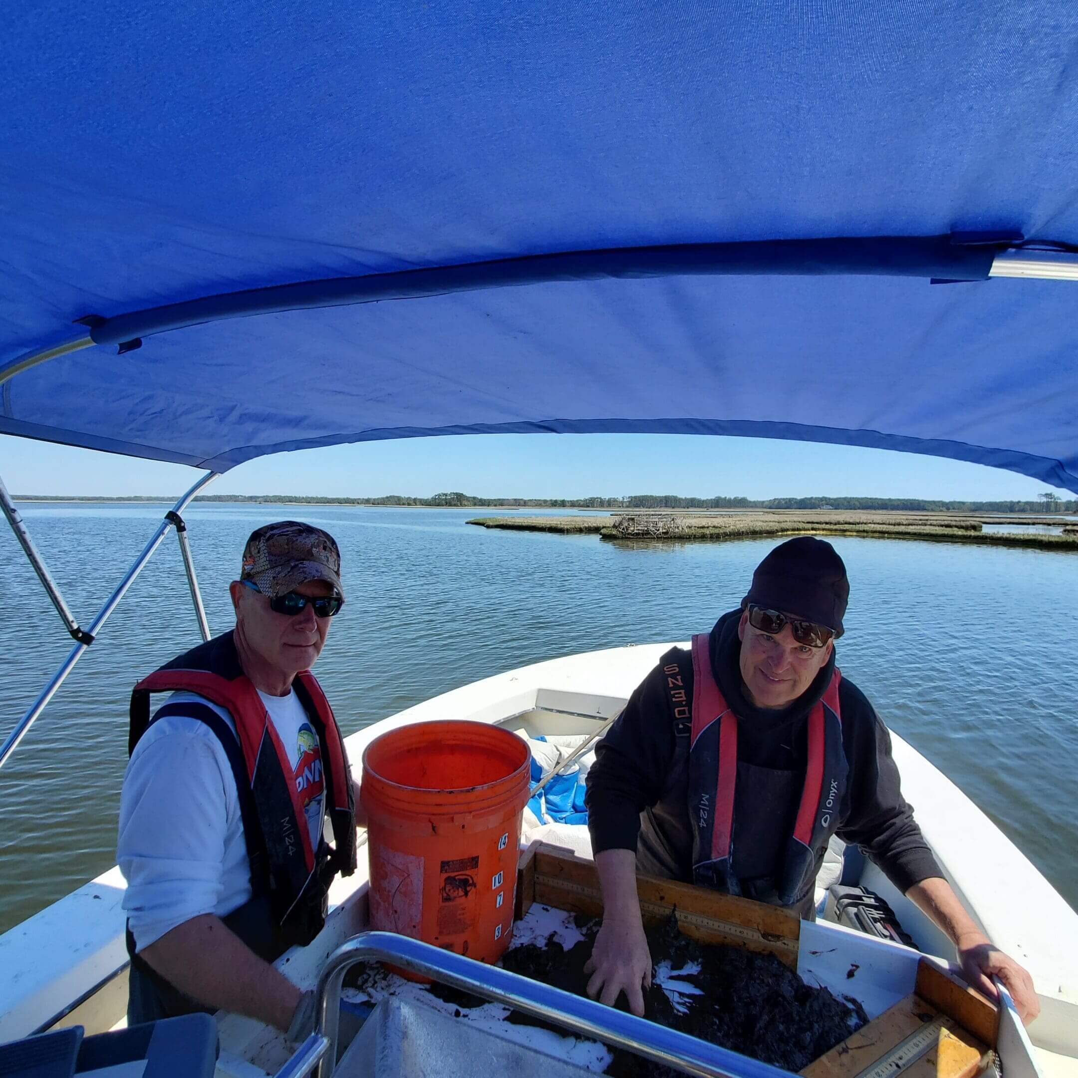 Two men in a boat on the water.